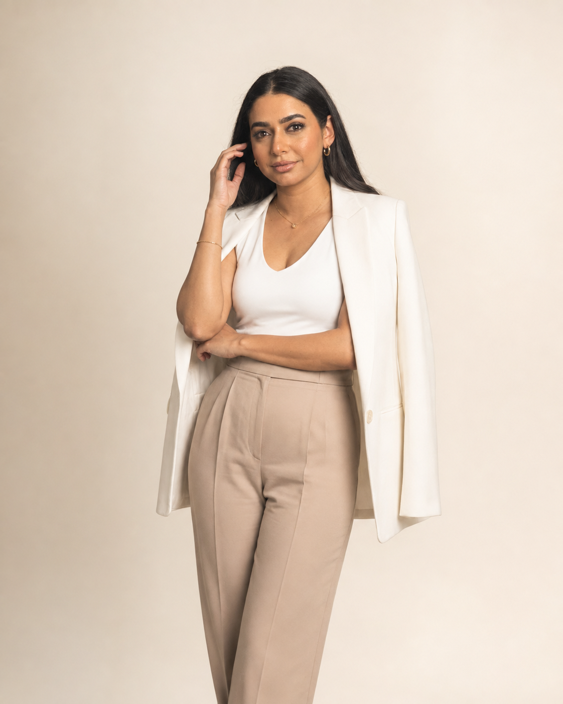 Amel Amamou, Tunisian entrepreneur and business builder, standing in a cream blazer and tan trousers.